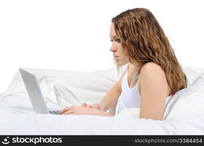 young woman with laptop lying on the bed. Isolated on white background