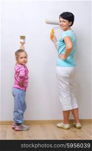 Young woman with little girl doing home repair