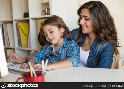 Young woman with little girl using computer at home