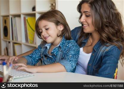 Young woman with little girl using computer at home