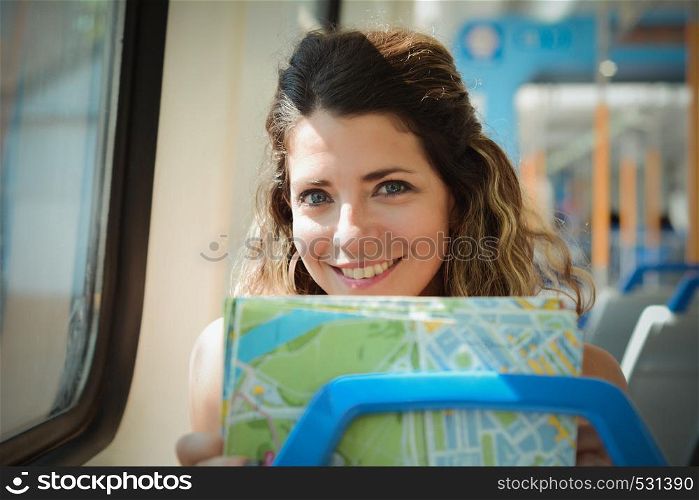 Young woman with map traveling by the train. Enjoying travel concept.