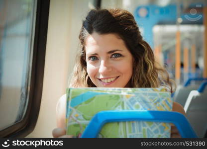 Young woman with map traveling by the train. Enjoying travel concept.