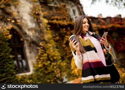 Young woman with mobile phone in autumn