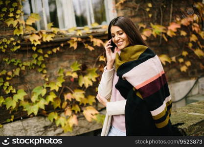 Young woman with mobile phone in autumn