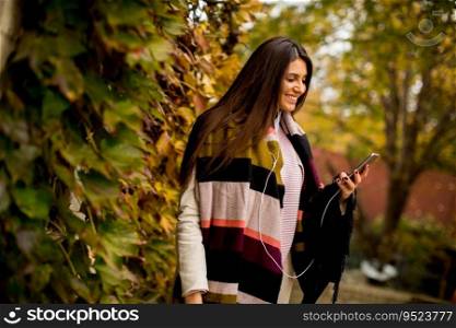 Young woman with mobile phone in autumn outdoor