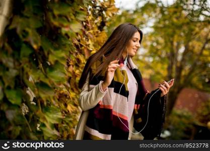 Young woman with mobile phone in autumn outdoor