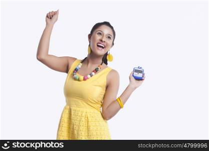 Young woman with mobile phone rejoicing