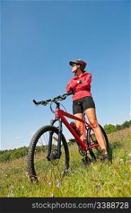 Young woman with mountain bike in spring nature on sunny day