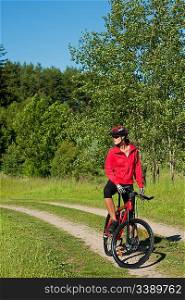 Young woman with mountain bike in the nature on a sunny day