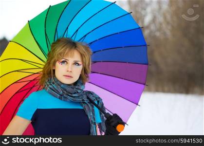 Young woman with multicolor umbrella at forest