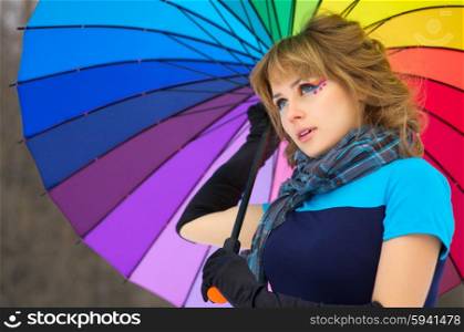 Young woman with multicolor umbrella at winter forest