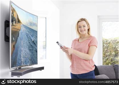 Young Woman With New Curved Screen Television At Home