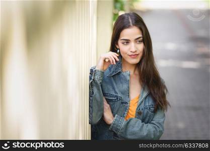 Young woman with nice hair wearing casual clothes in urban background. Happy girl with wavy hairstyle.