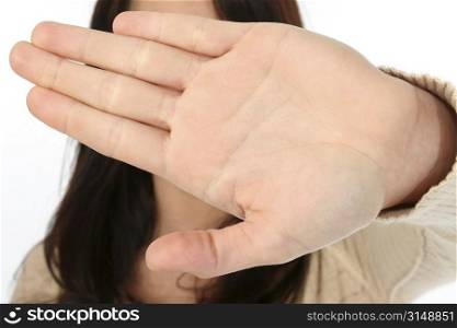 Young woman with open palm towards camera. Shot in studio over white.