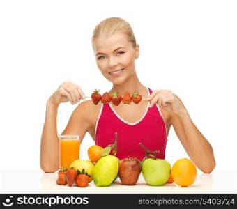 young woman with organic food or fruits eating strawberry