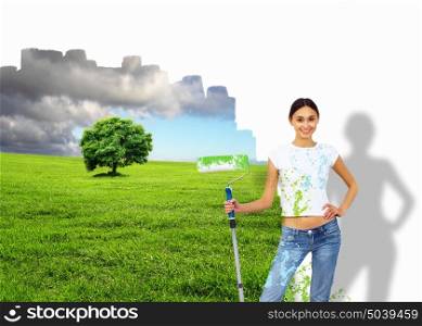Young woman with paint brush and wall with natural landscape