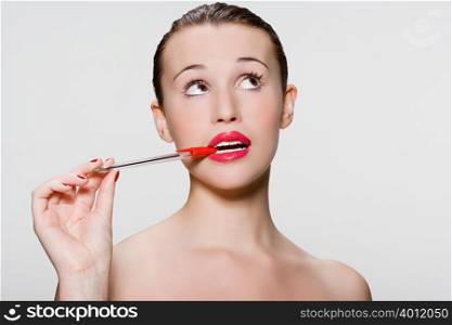 Young woman with pen in her mouth