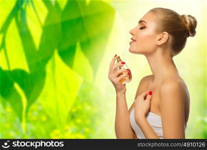 Young woman with perfume on floral spring background