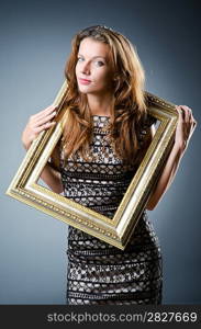 Young woman with picture frame on white