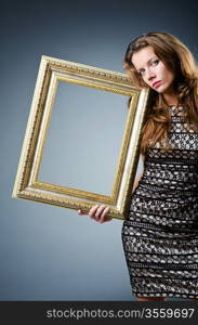 Young woman with picture frame on white