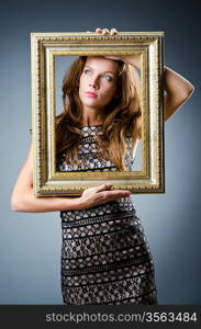 Young woman with picture frame on white