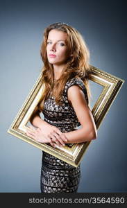 Young woman with picture frame on white