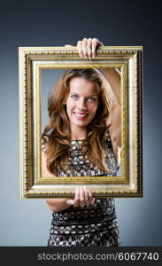 Young woman with picture frame on white