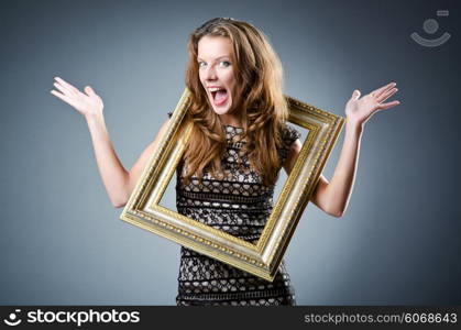 Young woman with picture frame on white