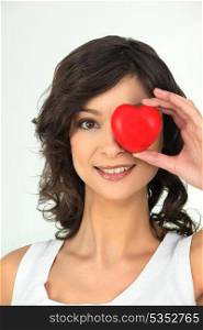 young woman with red heart on her eye