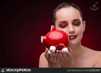 Young woman with red piggybank