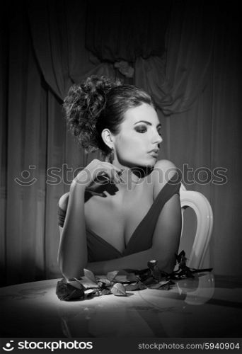 Young woman with rose flower sit on chair (monochrome version)