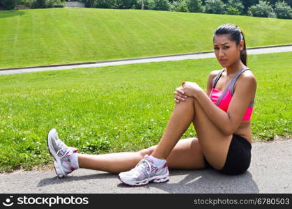 Young woman with running injury on knee