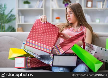 Young woman with shopping bags indoors home on sofa