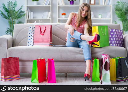 Young woman with shopping bags indoors home on sofa