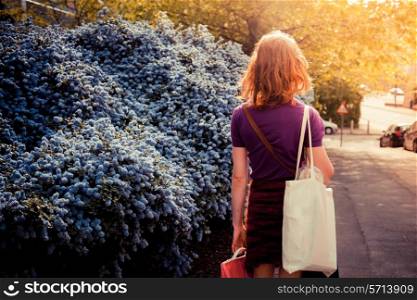 Young woman with shopping bags is walking in the street on a sunny day