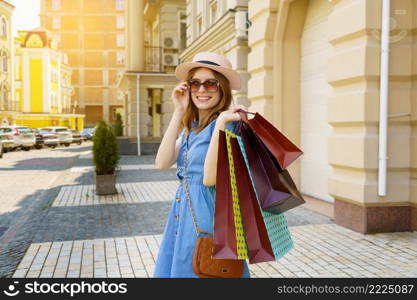 Young Woman with shopping bags walking in a city at summer day.. Young Woman with shopping bags walking in a city at summer day