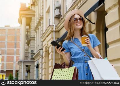 Young Woman with shopping bags walking in a city at summer day.. Young Woman with shopping bags walking in a city at summer day