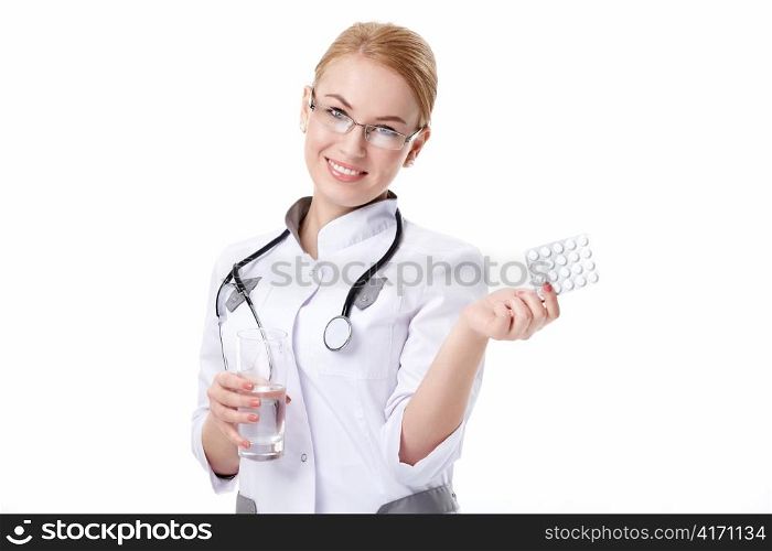Young woman with stethoscope and pills on a white background