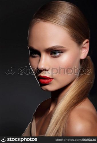 Young woman with straight hair and and red lips on dark background. Portrait.