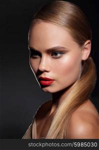 Young woman with straight hair and and red lips on dark background. Portrait.