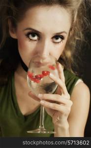 young woman with stylish hair drinking white wine from the glass with hearts