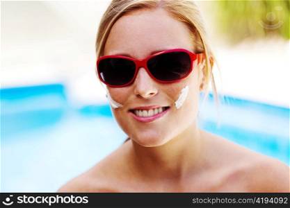 young woman with sunglasses in the summer and sun cream
