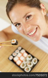 young woman with sushi smiling