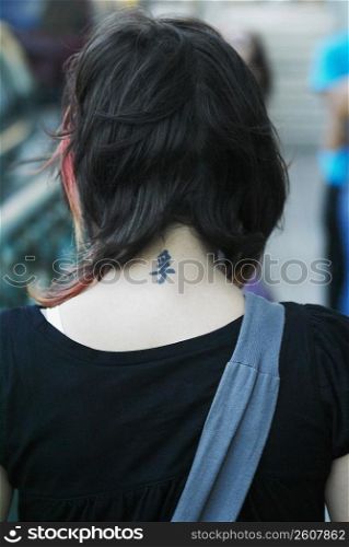 Young woman with tattoo on back of neck