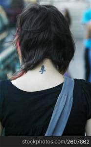 Young woman with tattoo on back of neck