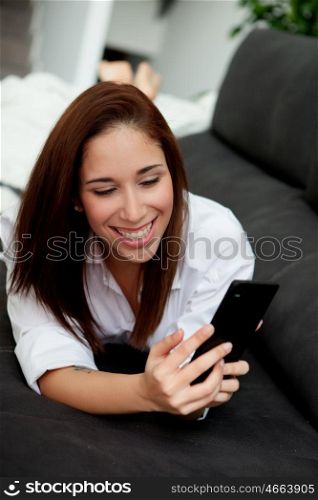 Young woman with the mobile on the sofa at home
