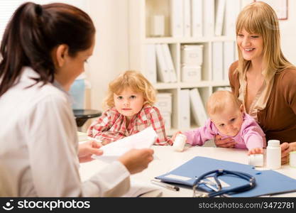 Young woman with two little children girl speak to pediatrician