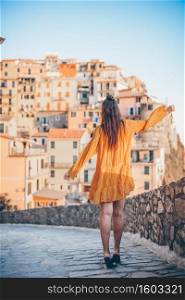 Young woman with view of amazing village of Manarola, Cinque Terre, Italy. European vacation.. Tourist looking at scenic view of Manarola, Cinque Terre, Liguria, Italy
