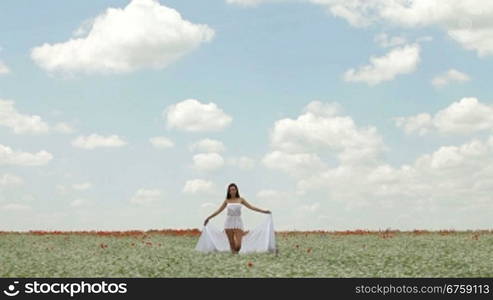 Young Woman With White Scarf Walking In a Field