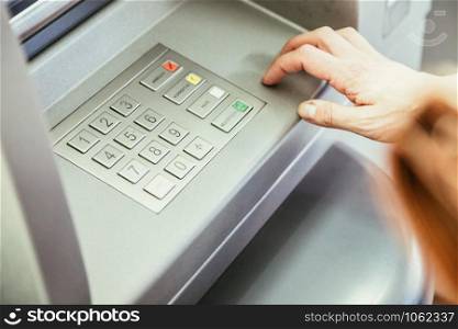 Young woman withdrawing money from a cash machine